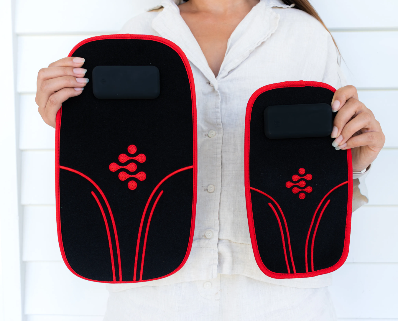 Woman holding the Body Wrap Plus and the Body Wrap side by side, showing their relative size