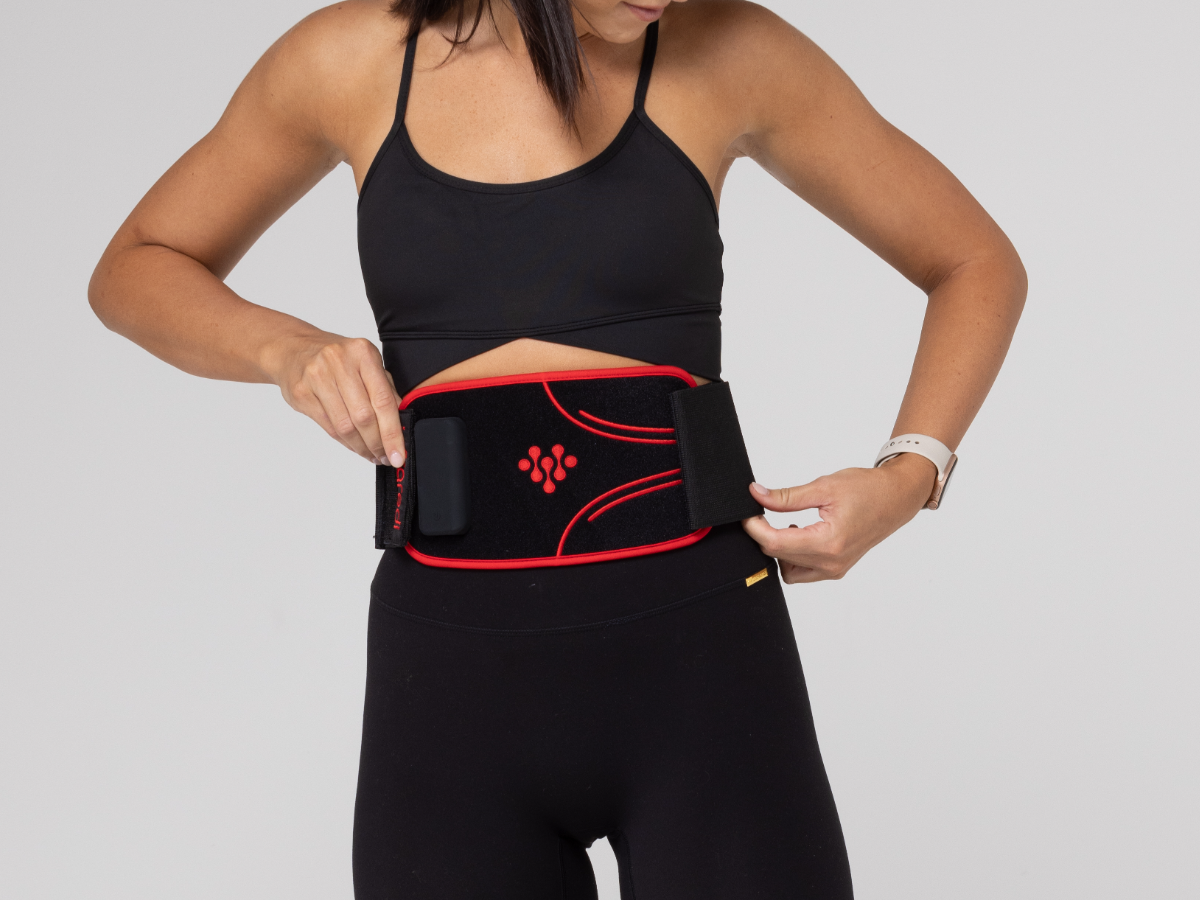 Woman fastening an Infraredi Body Wrap around her abdomen